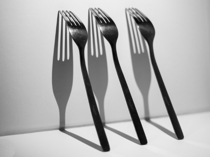 Image of three forks with their shadows on the wall