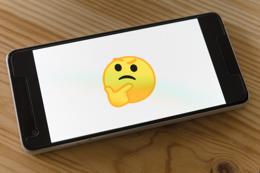 Photo of a smart phone with the thinking emoji displayed on it